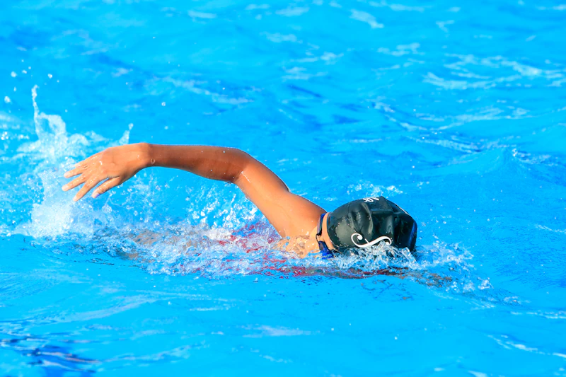 Nadador realizando uma braçada em piscina